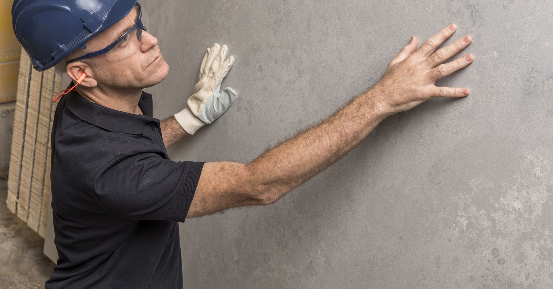 עובד בוחן משטח קוורץ/פורצלן של אבן קיסר לפני תחילת העבודה, כשהוא מצמיד את ידיו למשטח ובודק את אחידות הטקסטורה.