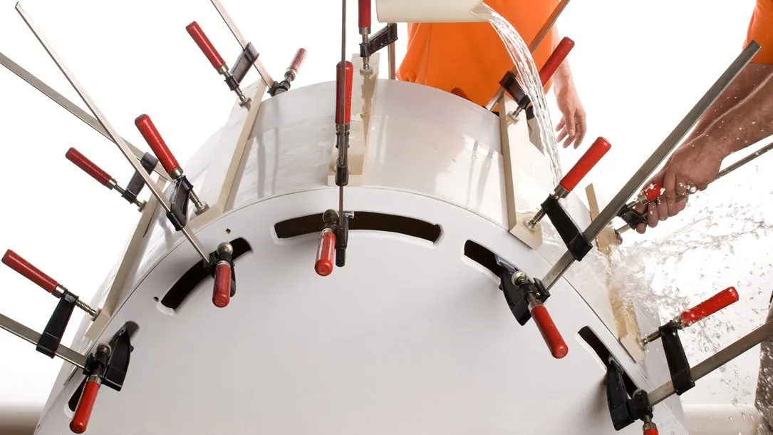 תהליך כיפוף בחום של משטח אבן קיסר באמצעות קליבות והזרמת מים לקירור.