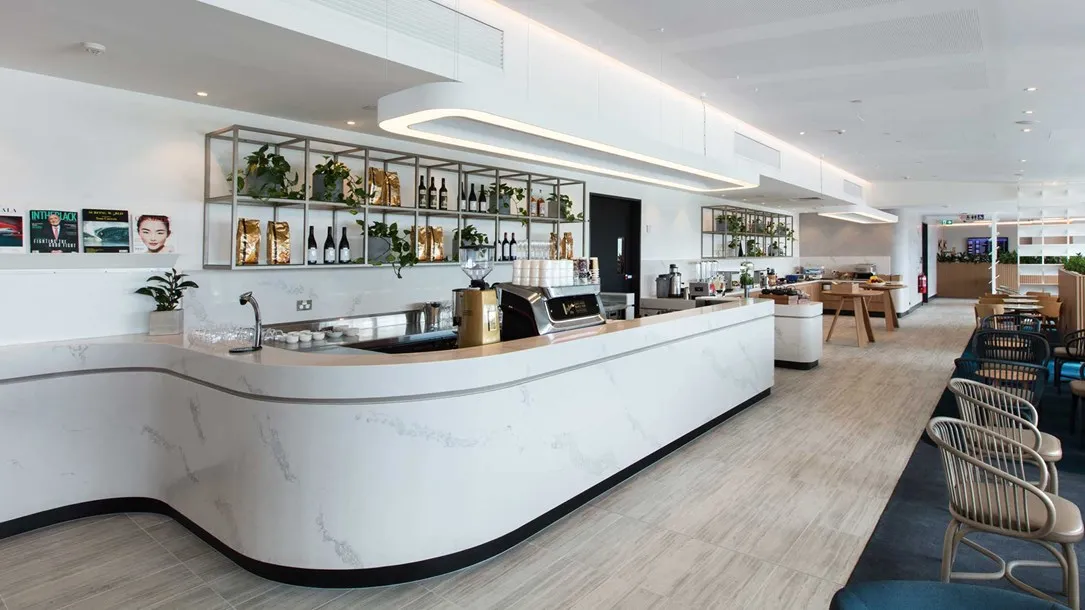 דלפק מעוצב מאבן קיסר עם חזית וכיפוף בחום בחלל אירוח מודרני